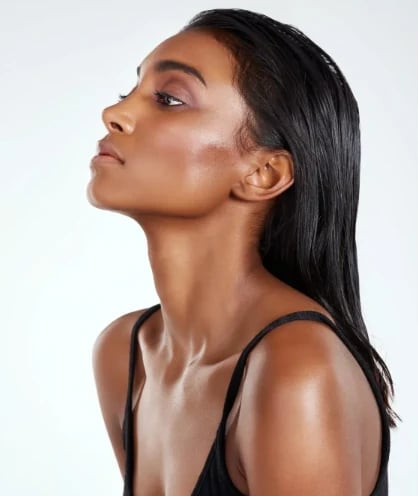 Woman in profile with long dark hair, chin lifted to show the neck and jawline