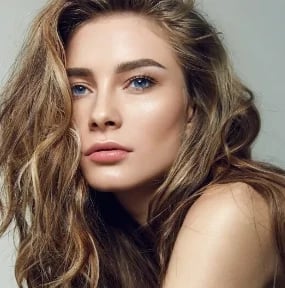 Close portrait of a woman with long wavy hair and calm, smooth facial features